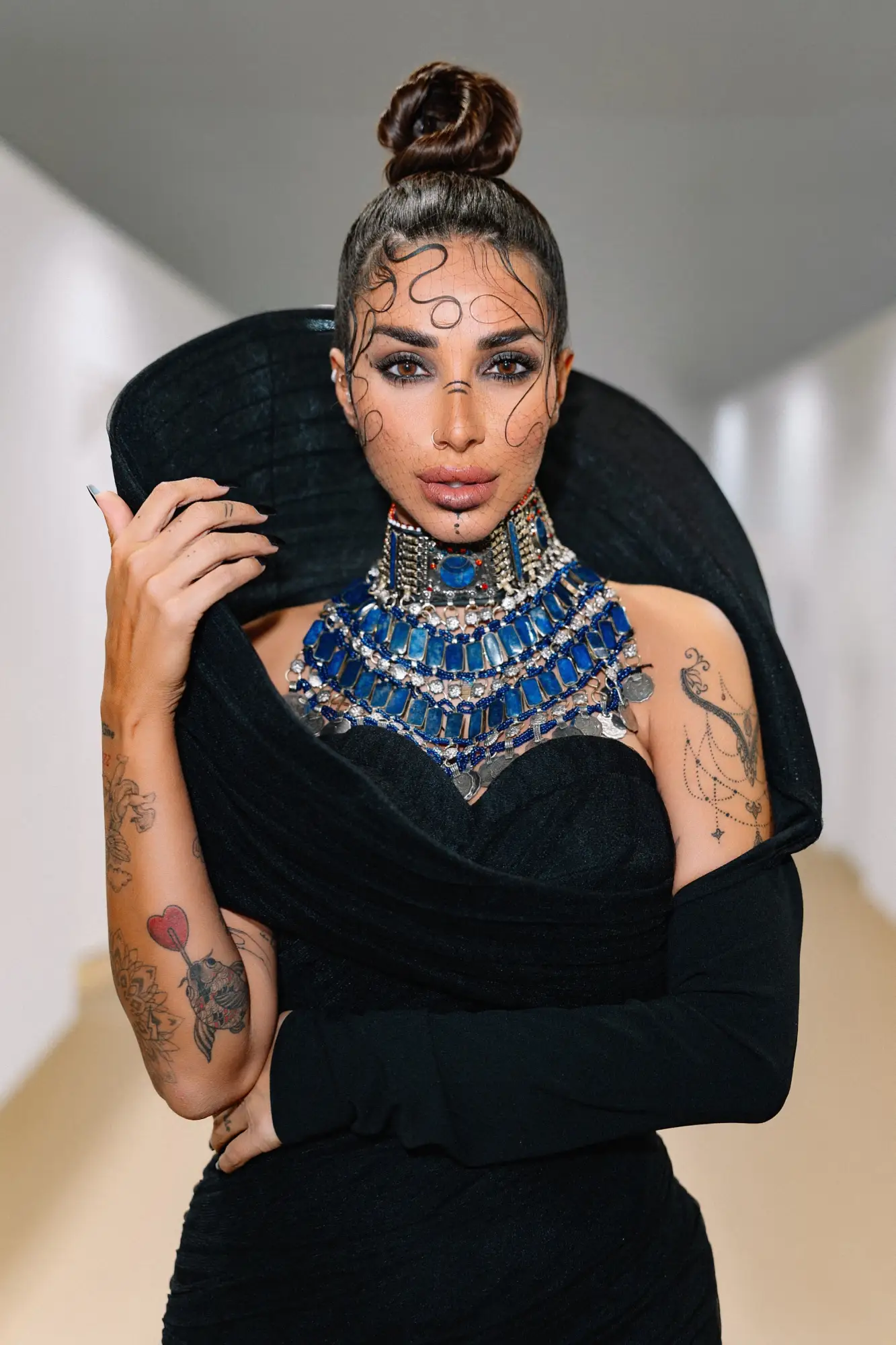 Sara Al Madani in a black gown with blue jewellery