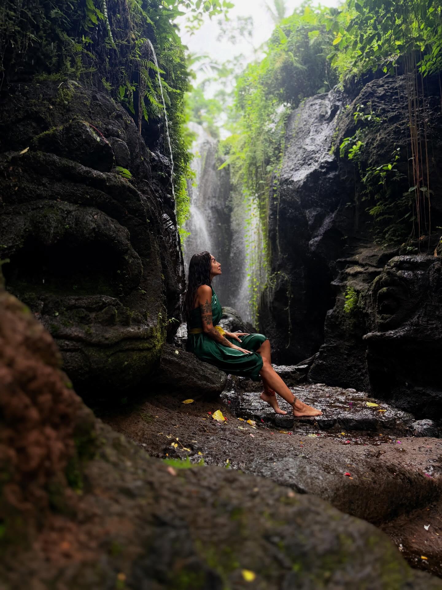 Sara Al Madani seated beside a waterfall