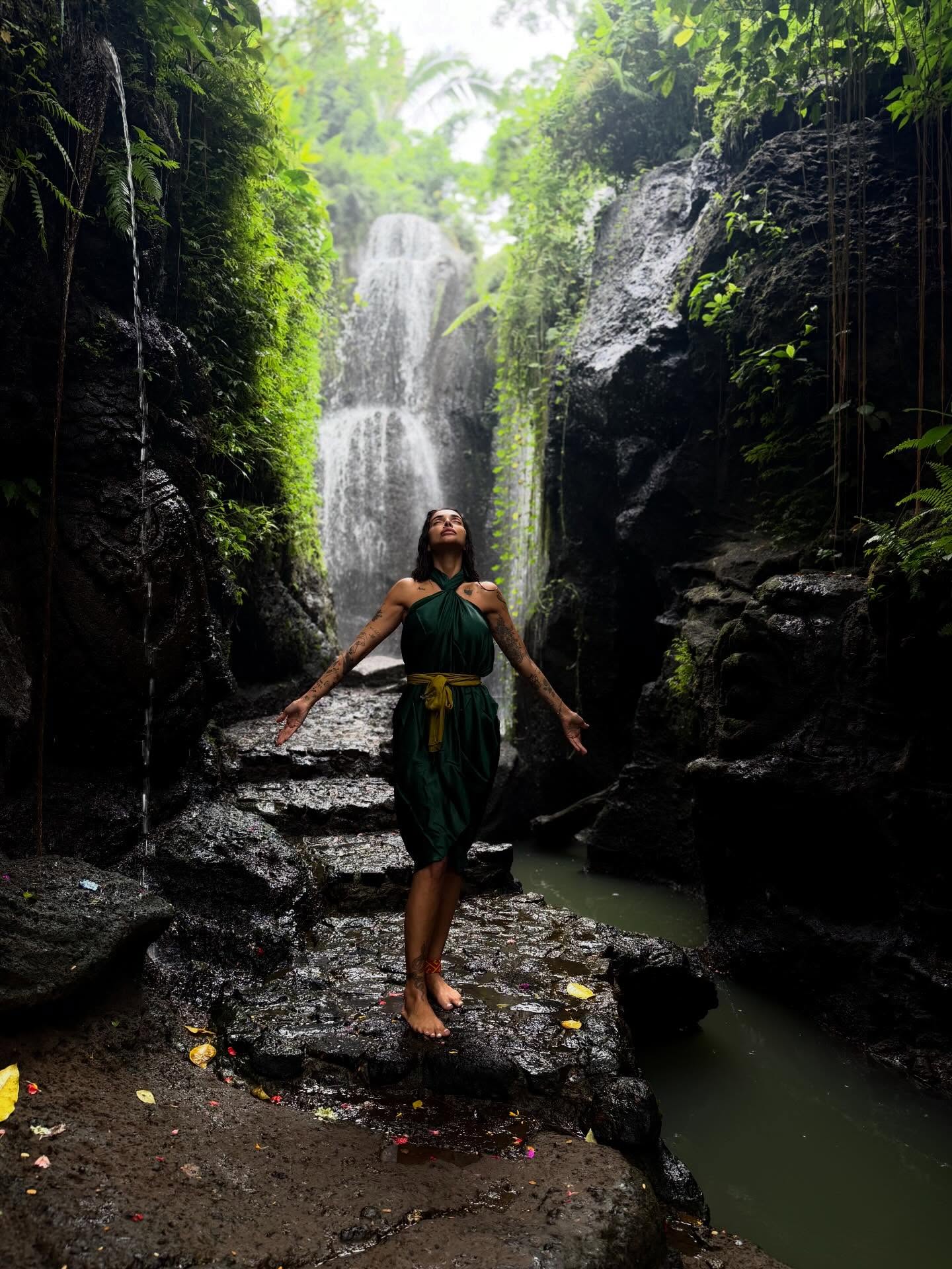 Sara Al Madani standing before a waterfall